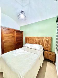 伊斯塔帕Sweet home Ixtapa comfort的一间卧室配有一张大床和木制床头板