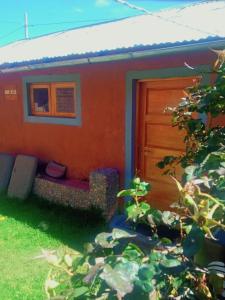 普诺TITICACA'S SALA UTA的一座橙色的房子,在门前设有一张红色的沙发