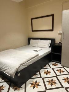 因帕尔OYO Flagship The Thangal Hotel的卧室配有一张床铺,铺有黑白色的地板