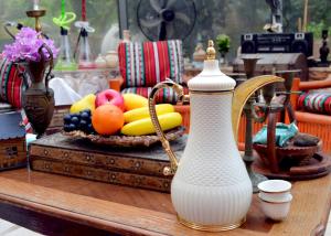 杰拉什بيت الطبيعة nature house的一张桌子,上面有白色花瓶和一篮水果
