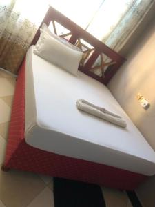 坦噶Cam Lodge的客房内的一张红色和白色的床