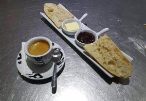 比斯卡罗斯BISCADODO, joignable au zéro6trente53cinquante60的一张桌子,上面放着一杯咖啡和一盘面包