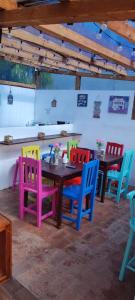 圣克里斯托瓦尔-德拉斯卡萨斯Suites del Barrio的餐桌旁的用餐室,配有五颜六色的椅子