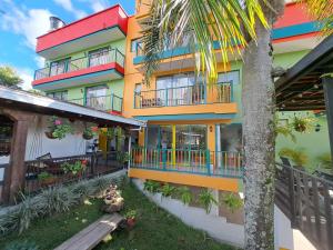 瓜塔佩Guatapé Country House Hotel的色彩缤纷的建筑,设有阳台和棕榈树