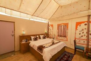 斋沙默尔Royal Rangers Desert Safari Camp的一间卧室配有一张床和一把椅子