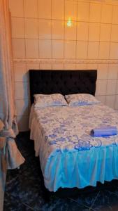 瓜鲁柳斯Casa kitnet的一间卧室配有一张带蓝色棉被的床