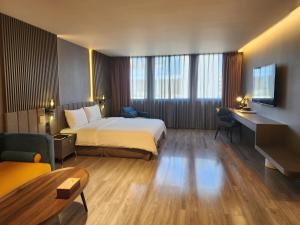 花莲市花蓮品悅文旅Hualien Pink Corner Hotel的配有一张床和一张书桌的酒店客房