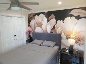 Cooperʼs TownOcean View Utopia的卧室配有一张挂着花壁画的床。