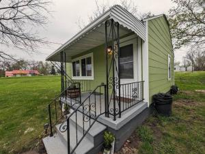 弗林特Sleek and Central Small Home Close to everything的一座带前廊和楼梯的绿色小房子