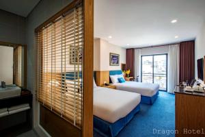 胡志明市Golden Dragon Hotel Sài Gòn的酒店客房设有两张床和盥洗盆