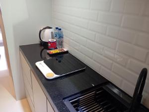 巴淡岛中心SleepRest @ Pollux Habibie的厨房配有带水槽的黑色台面