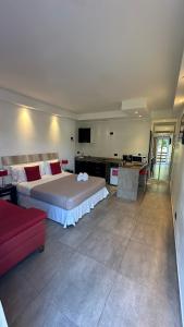 皮纳马尔艾尔斯村公寓式酒店的一间卧室配有一张大床和一张红色的沙发