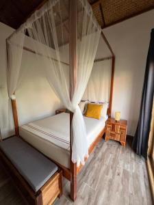 爱妮岛ANITSA RESORT的一间卧室配有两张床和一张天蓬床。