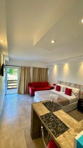 皮纳马尔艾尔斯村公寓式酒店的酒店客房带两张床和一张红色沙发