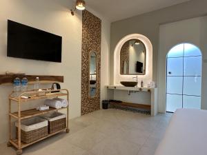 龙目岛库塔El Tropico Boutique Hotel的一间带水槽的浴室和墙上的电视
