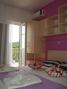 米欧纳Apartments Kiro的卧室配有带枕头的床铺和窗户。