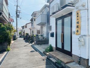 神户KOBE coffee hostel的街道边有黑色门的建筑物