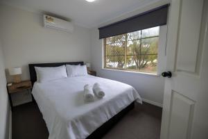 珀斯Urban Oasis Hideaway的卧室配有白色的床和窗户。