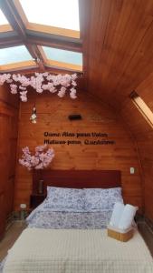 派帕Glamping VILLA - Nueva en Paipa的卧室配有一张挂有墙上标志的床