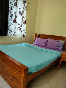 马迪凯里White bungalow的一间卧室配有一张带蓝色床单的床和一扇窗户。