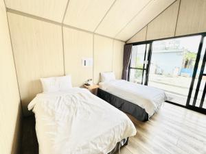 小琉球岛小杉丘民宿的带窗户的客房内的两张床