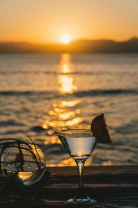 爱妮岛Parada Beach Camp的日落时在海滩上喝一杯,喝一杯太阳镜