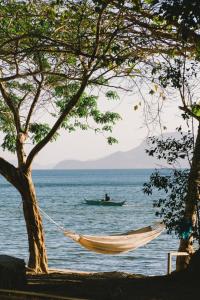 爱妮岛Parada Beach Camp的海滩上的吊床,船上有男人