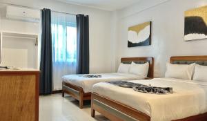 长滩岛The XIMO Suites的酒店客房设有两张床和电视。