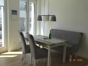 诺德奈Old Printing House Holiday Apartment Bodoni的餐桌、椅子和一瓶香槟