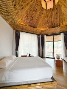 万荣Family Land Camping Resort的一间卧室设有一张带木制天花板的大床