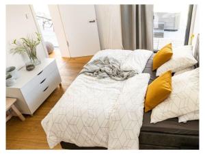 WaldershofFichtelTijd Wellness Sauna Whirlpool的一间卧室配有两张带黄色枕头的床