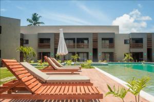 佩德拉斯港Refúgio em Condomínio Resort na Rota dos Milagres的一个带游泳池、躺椅和遮阳伞的度假村