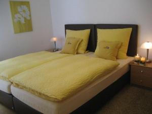 埃斯洛黑Krähenberg Country House的卧室配有一张带黄色床单和枕头的大床。