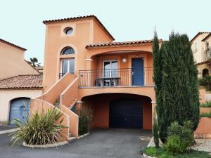 贝济耶Terrasse du golf的一座橙色的房子,设有大门和车库
