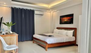 长滩岛The XIMO Suites的一间卧室配有一张床和一张桌子及椅子