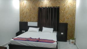 HazārībāgHotel Alakhraj Palace的一间卧室配有一张白色的床和黑色床头板