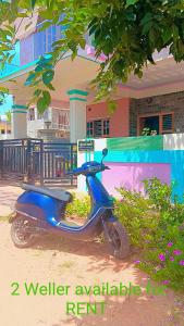 迈索尔Kailash Guest Home的停在大楼前的蓝色摩托车