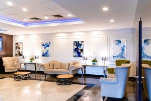 特尔古穆列什商务酒店会议中心&Spa的大堂配有沙发、桌子和蓝色画作