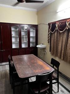 维沙卡帕特南The Padmavathi Guest House - Vizag的一间带木桌和椅子的用餐室