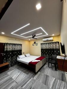 维沙卡帕特南The Padmavathi Guest House - Vizag的一间卧室配有一张床、一张书桌和一台电视