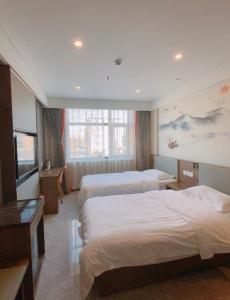 房山区比邻酒店(北京房山区良乡医院店)的酒店客房设有三张床和电视。