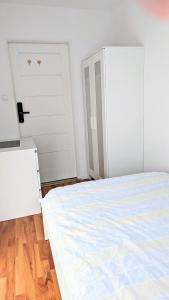 华沙Ursus Rooms-Self Check-in的卧室配有床和白色门