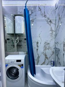 基希讷乌Apartment的一间带洗衣机和蓝色淋浴帘的浴室