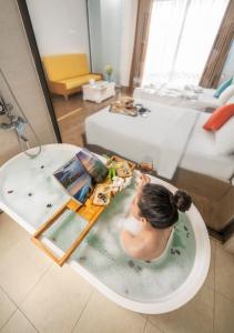 岘港Beach Hotel by RAON - STAY 24H的浴缸里的女人,在浴缸里吃一顿饭