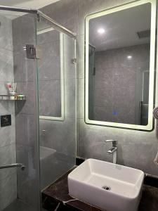 房山区比邻酒店(北京房山区良乡医院店)的浴室配有盥洗盆和带镜子的淋浴