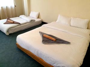 帕坦Hiti fusa的两张位于酒店客房的床,配有毛巾