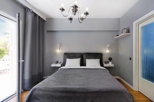 雅典Five Seasons Alimos的一间卧室配有一张大床和一个吊灯。