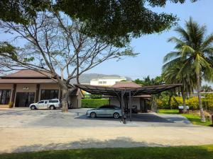 华欣Baan Mesuk Hua Hin Spa and Resort的停在大楼前停车场的汽车
