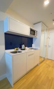 巴统Apartments Black Sea Resort的白色的厨房配有水槽和微波炉