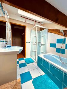 Créon-dʼArmagnacL'Escafouchot de Moulère的浴室铺有蓝色和白色的瓷砖,配有浴缸。